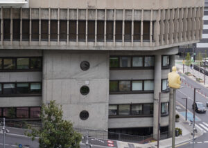 Edificio moderno con detalles arquitectónicos y figura en la entrada.