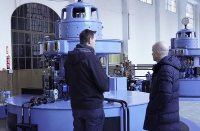 Dos personas conversando junto a maquinaria en la central hidroeléctrica de Encamp