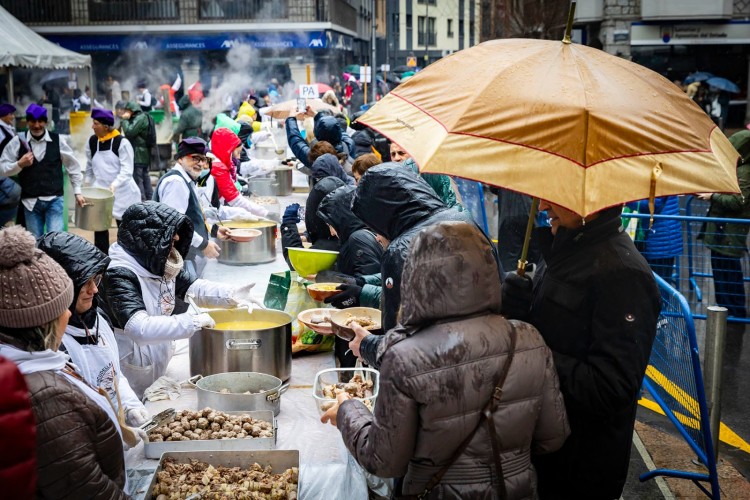 Cocineros preparando escudella en Andorra la Vella bajo la lluvia