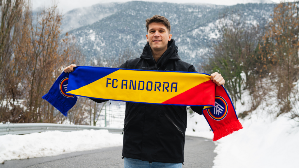 Marc Cardona sosteniendo una bufanda del FC Andorra en la nieve