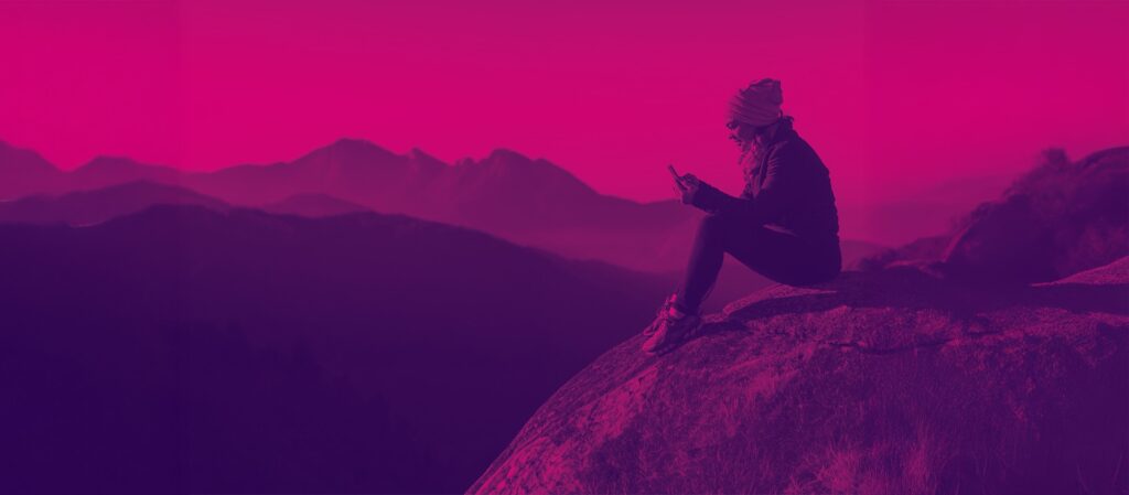 Persona usando un teléfono móvil en un paisaje montañoso de Andorra