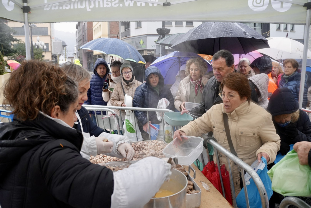 Personas en Sant Julià de Lòria disfrutando de la escudella de Sant Sebastià bajo la lluvia