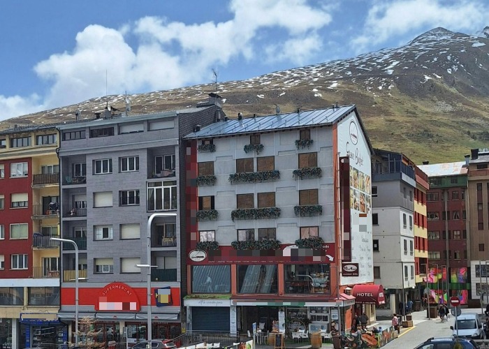 Edificios en Andorra con montañas al fondo y cielo nublado