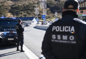 Policía en una carretera con vehículos y paisaje montañoso al fondo.