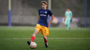 Jugador del Cadete S15 corriendo con el balón en un partido de fútbol