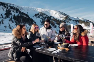Grupo de personas disfrutando de una comida en la montaña nevada de Andorra