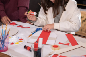 Niña creando un minilibro en taller de Carnaval en la biblioteca