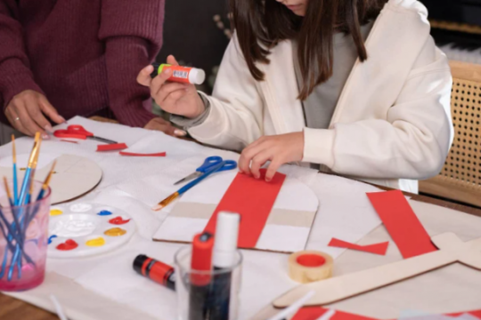 Niña creando un minilibro en taller de Carnaval en la biblioteca