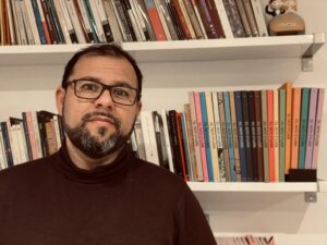 Toni Mata posando frente a una estantería llena de libros