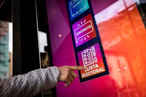 Persona señalando un cartel de lista electoral en Andorra la Vella