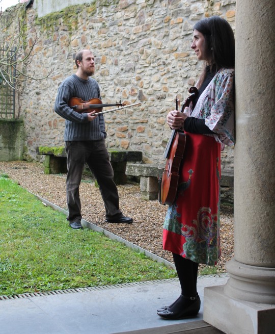 Músicos con violines en un entorno al aire libre