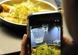 Persona tomando una foto de un plato de comida en un evento gastronómico