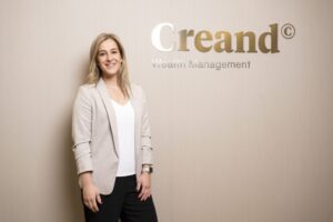 Mujer sonriente en un entorno profesional de gestión de patrimonio