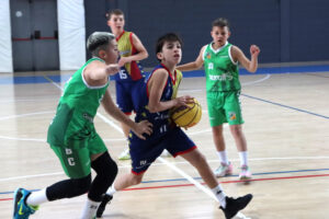 Jugadores del Mini Vermell compiten contra el CB Cerdanyola Nuroil A en un partido de baloncesto.
