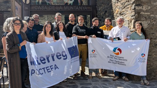 Grupo de personas sosteniendo banderas en el seminario del proyecto POCTEFA en Ordino.