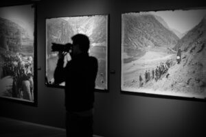 Persona fotografiando una exposición de fotografías históricas en Andorra