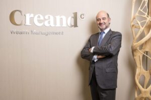 Ejecutivo de banca privada en oficina moderna con logo de Creand Wealth Management
