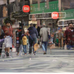 Personas caminando en una calle de Andorra con tiendas visibles