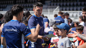 Niños interactuando con jugadores en un entrenamiento de puertas abiertas