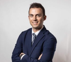 Hombre sonriente con traje y corbata en fondo blanco