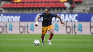 El jugador Jastin corriendo en el campo durante un partido de fútbol.