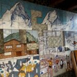 Mosaic cerámico de Sergi Mas en la fábrica de Arinsal, con montañas y escenas de agua.