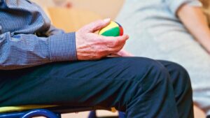 Persona mayor sosteniendo una pelota de colores en un centro sociosanitario