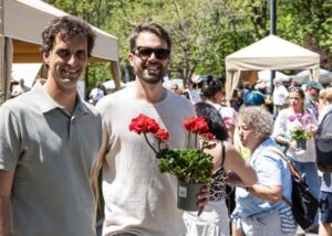 Dos hombres sosteniendo geranios en un evento floral en La Massana.