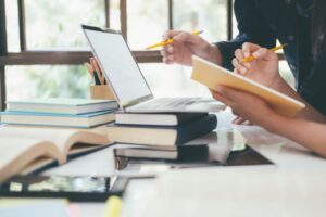 Estudiantes revisando documentos y trabajando en una laptop