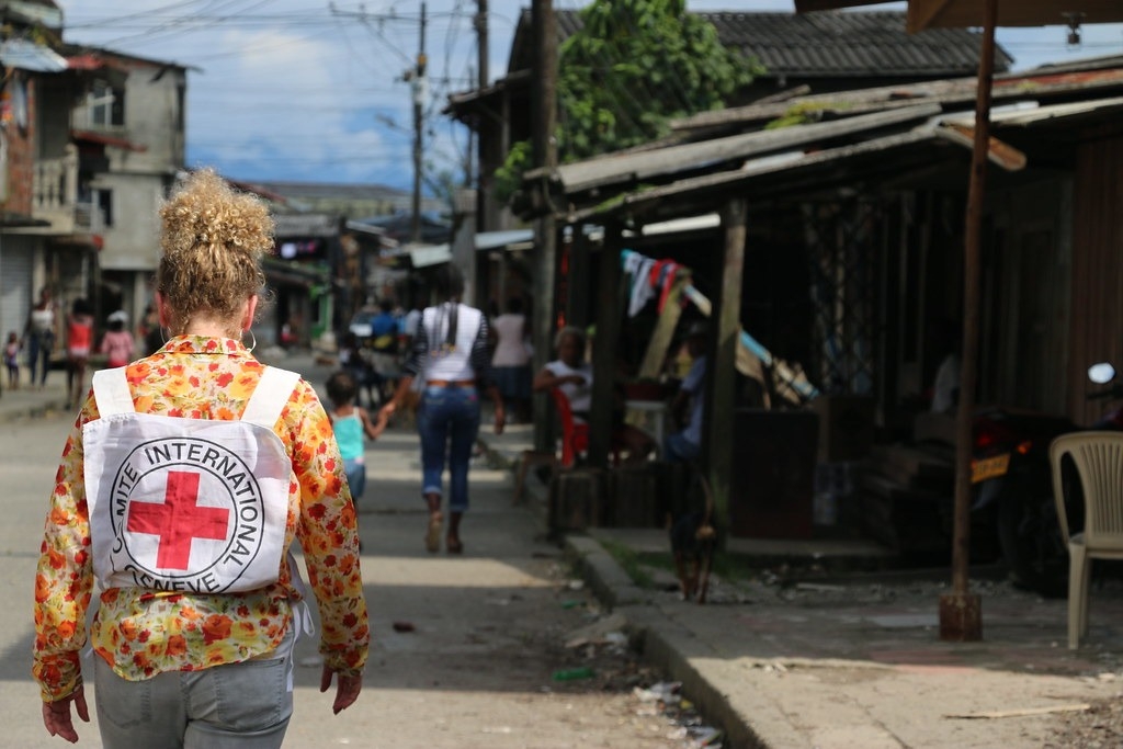 Persona con mochila de la Cruz Roja caminando por una calle