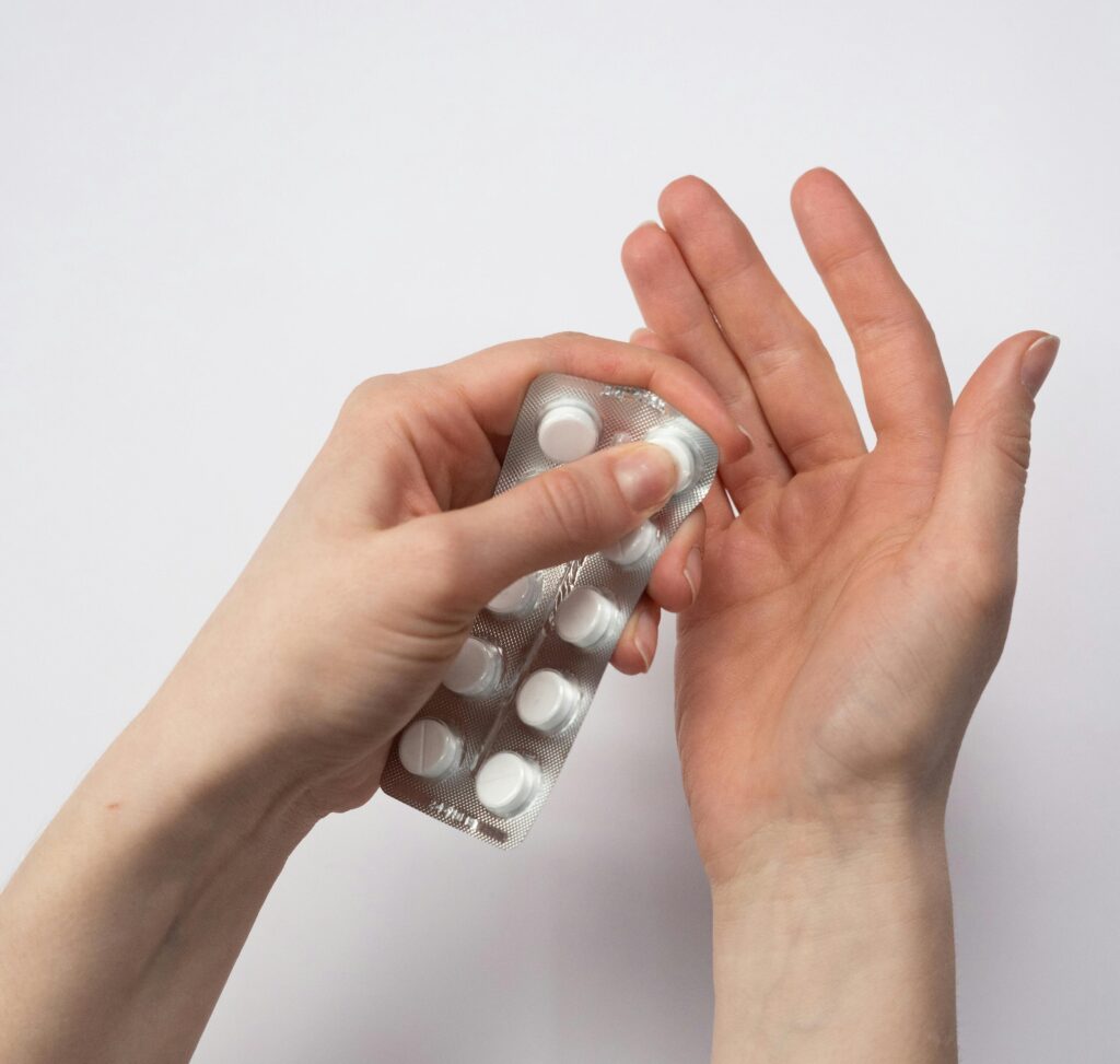 Persona sosteniendo un blíster de medicamentos en la mano