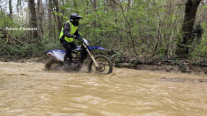 Policía andorrano conduciendo una moto en un terreno complicado durante la formación en Francia.