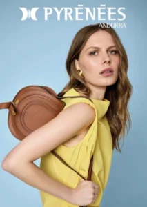 Modelo con blusa amarilla y bolso marrón en fondo azul