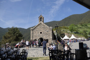 Vista del Aplec de Canòlich con asistentes y la iglesia de fondo