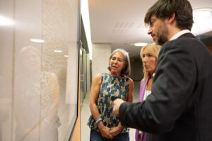 Tres personas observando la obra de Joana Baygual en el Consell General