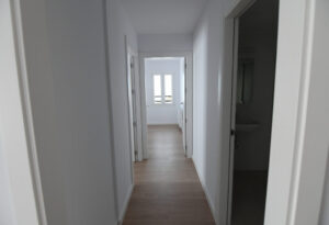 Pasillo de un apartamento con puertas y ventanas iluminadas
