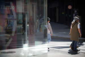 Personas cruzando una calle en Andorra con edificios de fondo