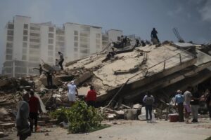 Personas en la escena de un terremoto en Venezuela con edificios colapsados.
