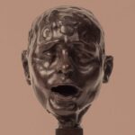 Escultura contemporánea representando un rostro con expresión intensa.