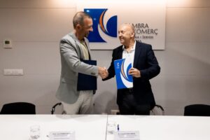 Dos hombres estrechando manos tras firmar un convenio de formación digital.
