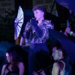 IAN actuando en la Serenalla Market con paraguas y vestuario llamativo