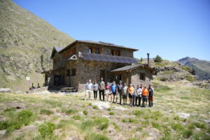 Grupo de personas frente al refugio guardat del Comapedrosa en Andorra