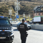 Agente de policía en carretera con vehículo patrullando en Andorra.