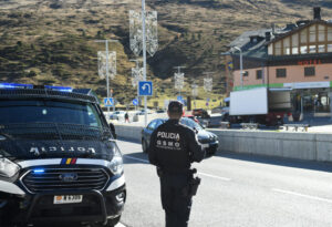 Agente de policía en carretera con vehículo patrullando en Andorra.