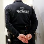 Agente penitenciario en uniforme en Andorra con las manos atrás