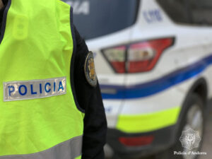 Uniforme de policía en primer plano junto a un vehículo policial