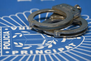Esposas sobre un fondo con el logo de la policía de Andorra.