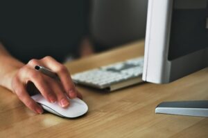Persona usando un ratón y un teclado en un entorno de trabajo digital