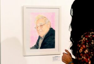 Retrato de un hombre en una exposición de arte con una persona observando