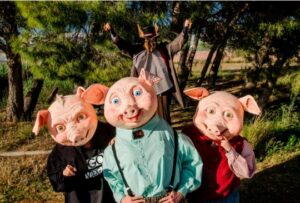 Tres cerditos con máscaras en un espectáculo de teatro al aire libre